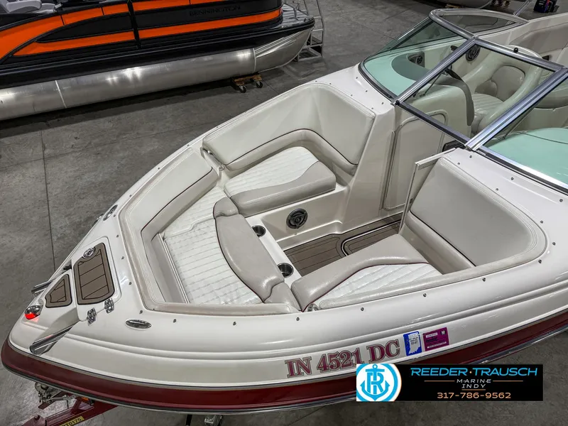 Slide: The Image of 2007 Bryant 240 boat with white interior, displayed indoors at Reeder-Trausch Marine. - 12
