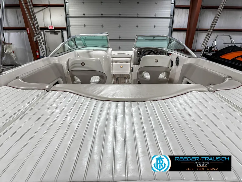 Slide: The Image of 2007 Bryant 240 boat interior with white leather seating in a garage setting. - 16