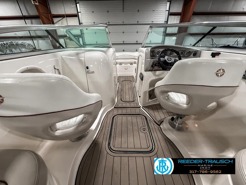 Slide: The Image of 2007 Bryant 240 boat interior with white seating and wood flooring in a garage. - 17