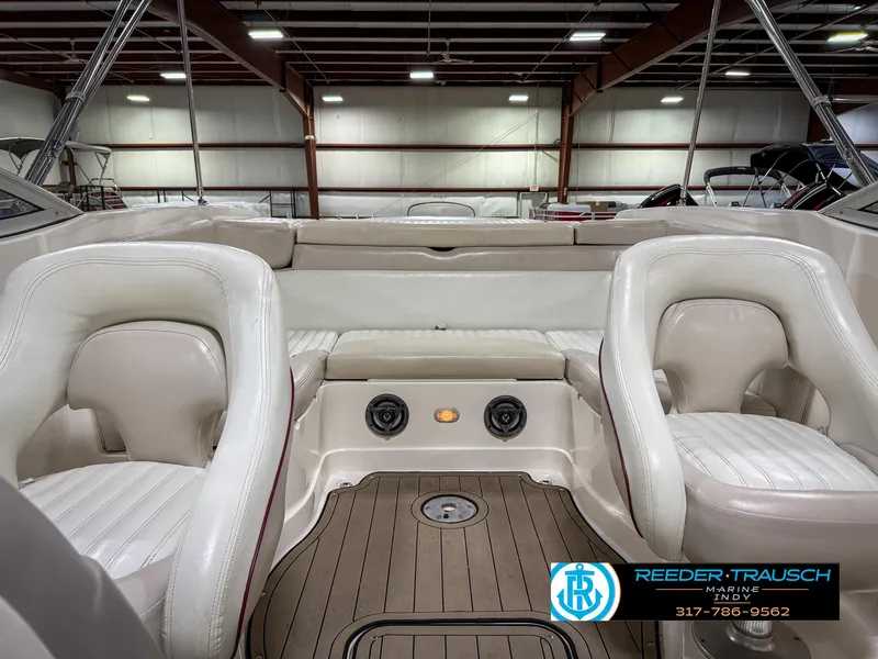 Slide: The Image of Interior of a 2007 Bryant 240 boat with white seating and wood flooring. - 20