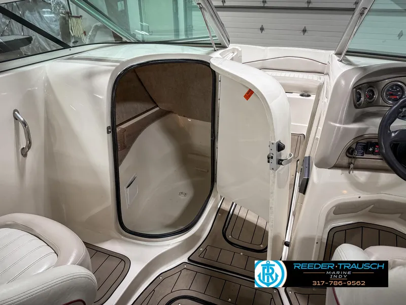 Slide: The Image of 2007 Bryant 240 boat interior with open cabin door, showcasing seating and dashboard. - 26