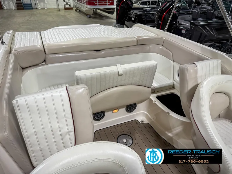 Slide: The Image of 2007 Bryant 240 boat interior with white seating and wood flooring, Reeder-Trausch Marine logo visible. - 28
