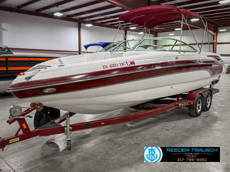 Slide: The Image of 2007 Bryant 240 boat with red accents on a trailer in a warehouse. - 3