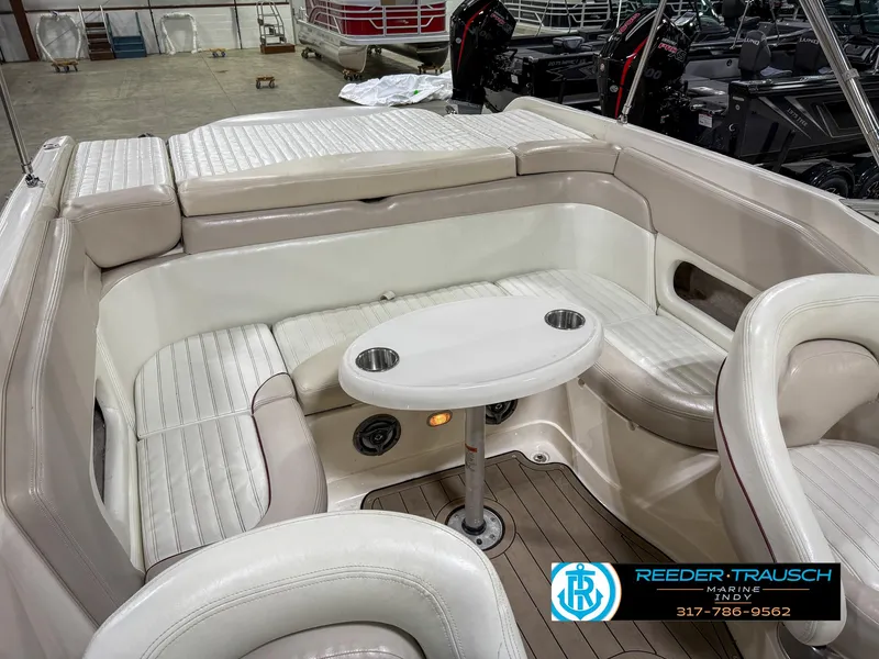 Slide: The Image of Interior of a 2007 Bryant 240 boat with beige seating and a small table. - 30