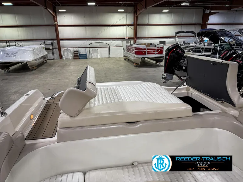 Slide: The Image of 2007 Bryant 240 boat interior in showroom, featuring white seating and Reeder-Trausch Marine logo. - 32