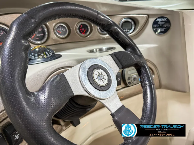 Slide: The Image of Steering wheel and dashboard of a 2007 Bryant 240 boat, featuring gauges and controls. - 36