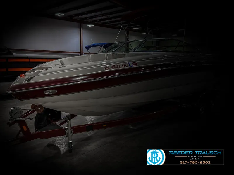 Slide: The Image of 2007 Bryant 240 boat on trailer in dimly lit indoor storage. - 4