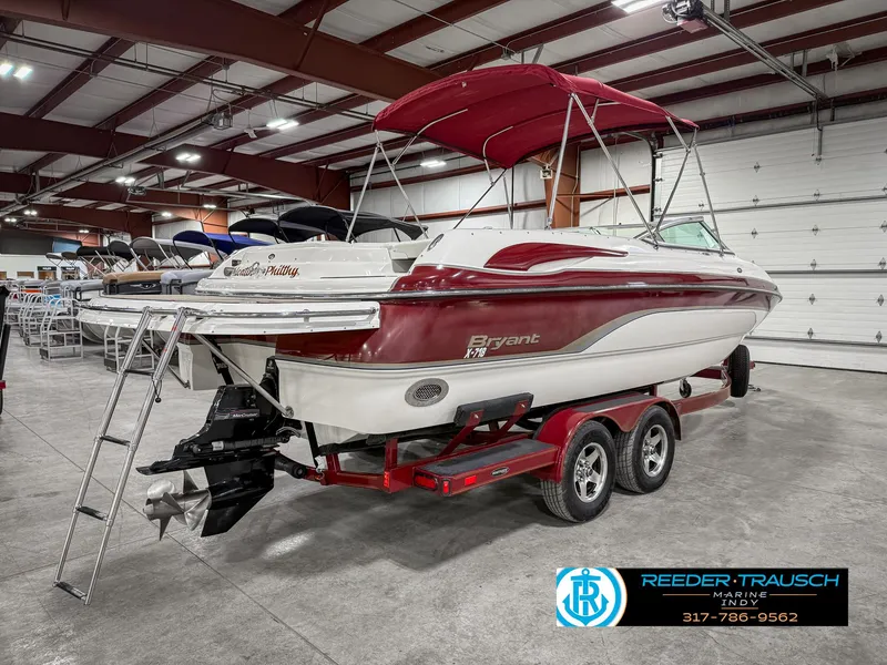 Slide: The Image of 2007 Bryant 240 boat with red accents on a trailer in a showroom. - 8