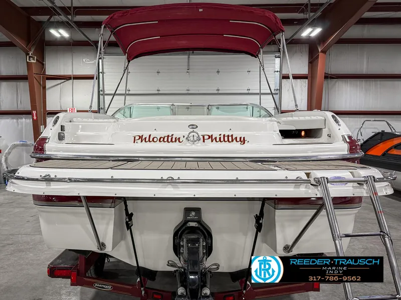 Slide: The Image of 2007 Bryant 240 boat with maroon canopy in a warehouse setting. - 9