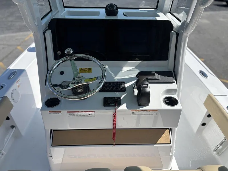 Slide: The Image of 2026 Sportsman Masters 227 Bay Boat interior with beige seating and storage compartments. - 12