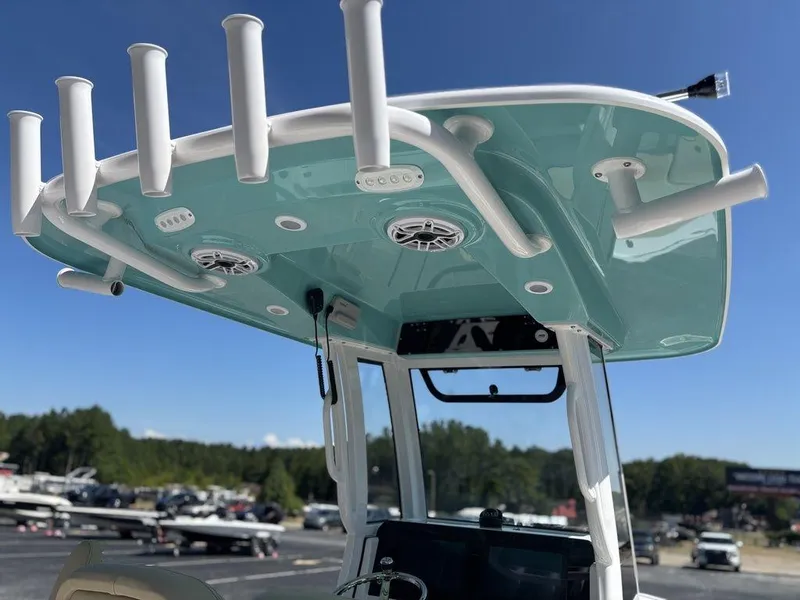 Slide: The Image of 2026 Sportsman Masters 227 Bay Boat with outboard motor, docked near a building. - 24