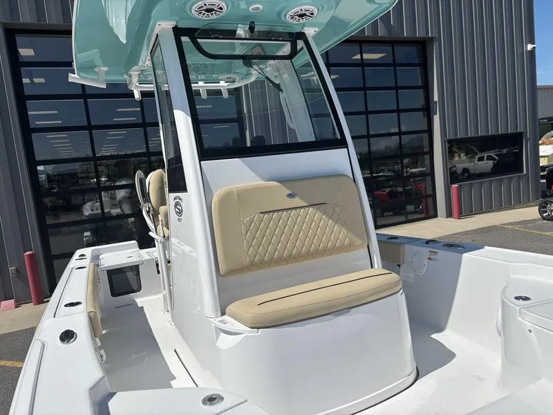 Slide: The Image of 2026 Sportsman Masters 227 Bay Boat, white exterior, beige seating, docked in a parking area. - 27