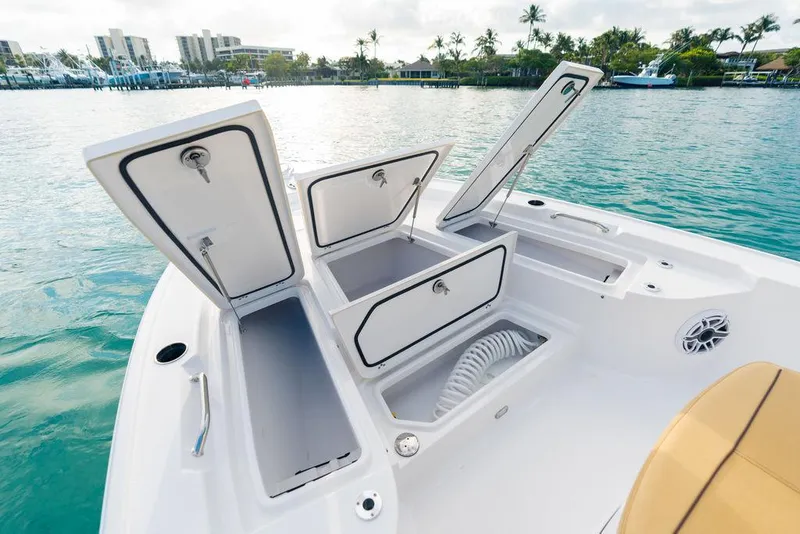 Slide: The Image of 2026 Sportsman Masters 227 Bay Boat with beige seating, docked near a modern building. - 34