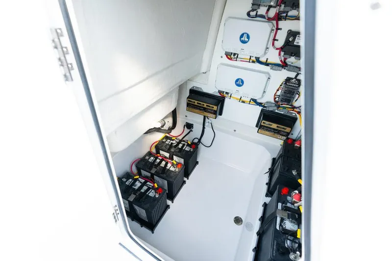 Slide: The Image of 2026 Sportsman Masters 227 Bay Boat with open storage compartments on calm water. - 40