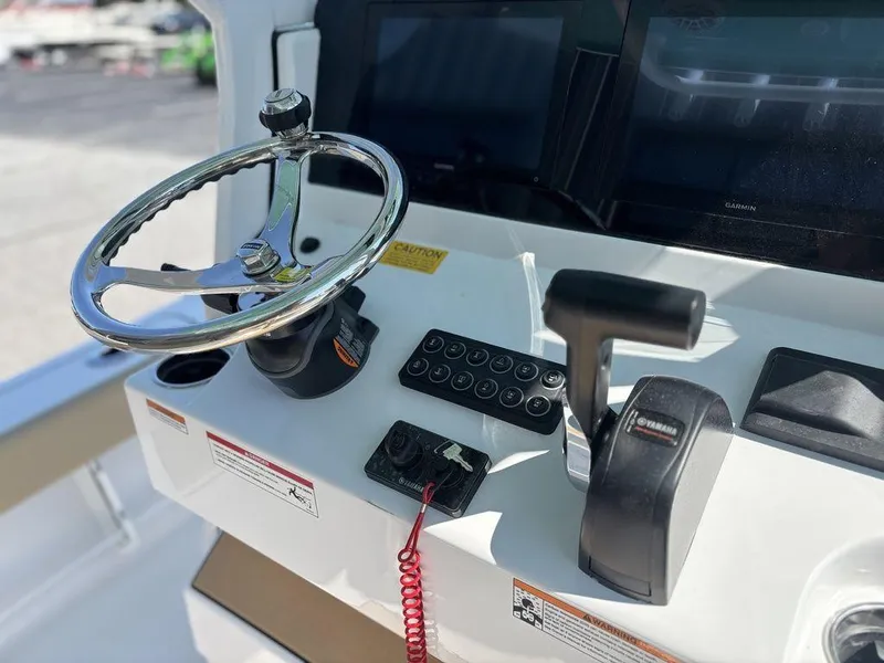 Slide: The Image of 2026 Sportsman Masters 227 Bay Boat on serene lake with waterfall backdrop. - 5