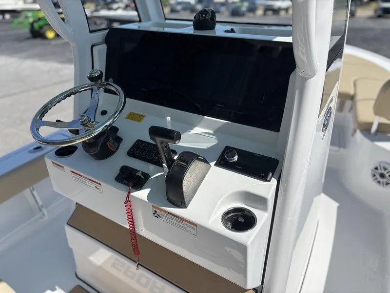 Slide: The Image of 2026 Sportsman Masters 227 Bay Boat with powerful outboard motor in parking lot. - 8