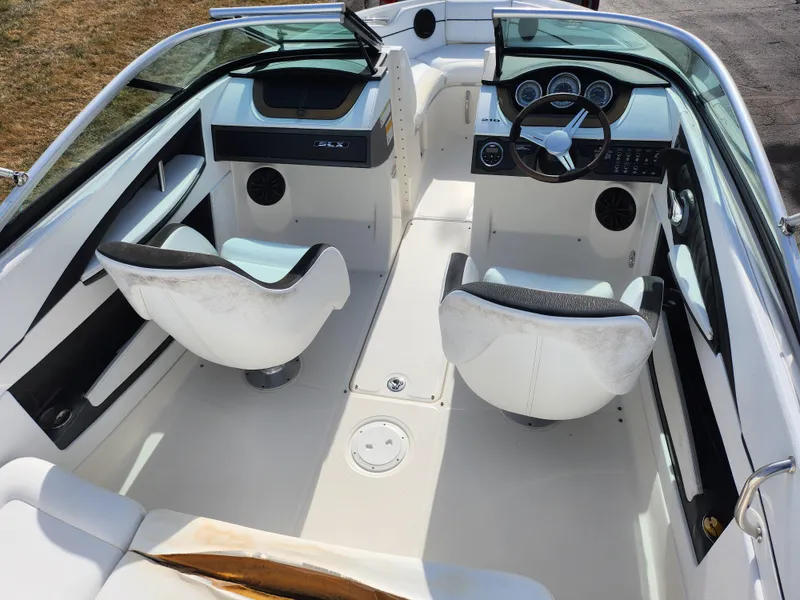 Slide: The Image of 2014 Sea Ray 210 SLX boat interior with dual seats and steering console. - 11