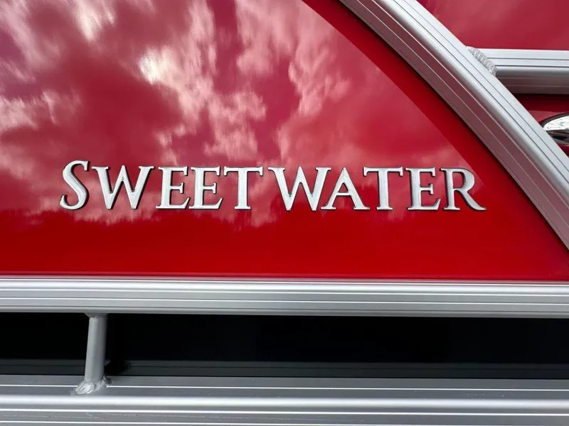 Slide: The Image of "Sweetwater 2286 SB" logo on red Godfrey boat, 2025 model. - 11
