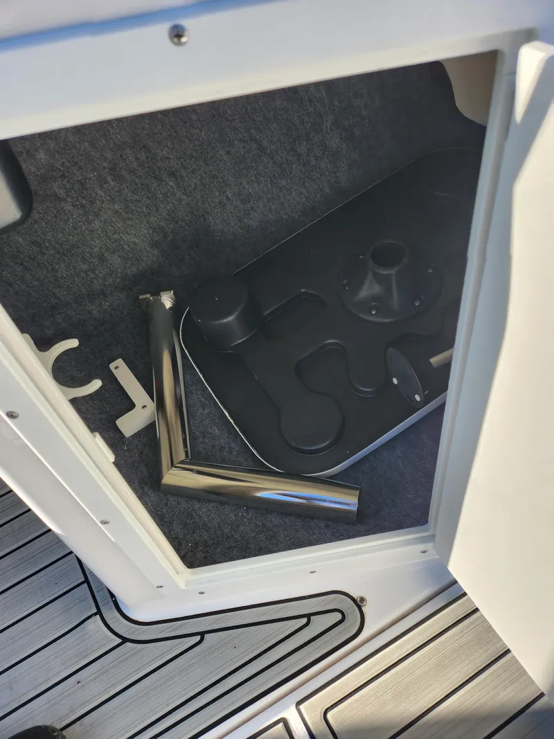 Slide: The Image of 2021 Yamaha AR195 boat storage compartment with metal parts and accessories. - 15