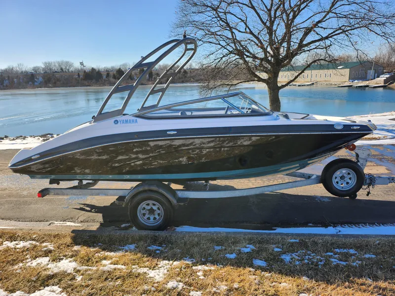 Slide: The Image of 2021 Yamaha Boats AR195 on trailer by a lake in winter setting. - 9