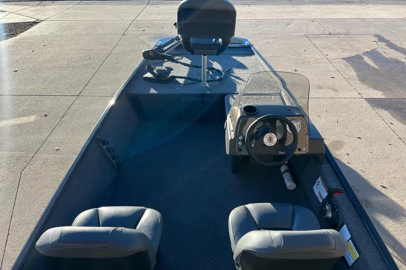 Slide: The Image of 2024 Tracker Bass Tracker Classic XL boat interior with steering wheel and seating. - 2