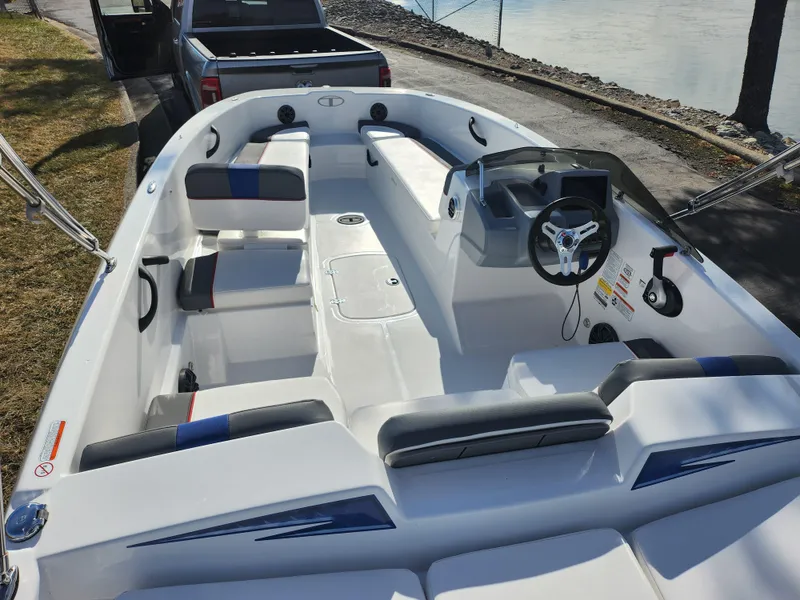 Slide: The Image of 2023 Tahoe T18 boat interior with seating and steering wheel, parked near a waterfront. - 11