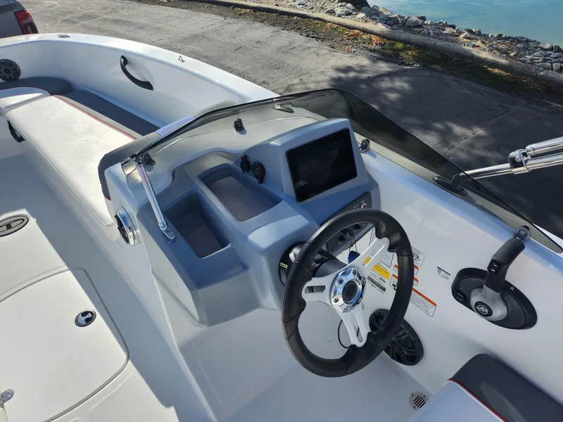 Slide: The Image of 2023 Tahoe T18 boat dashboard with steering wheel and control panel. - 12