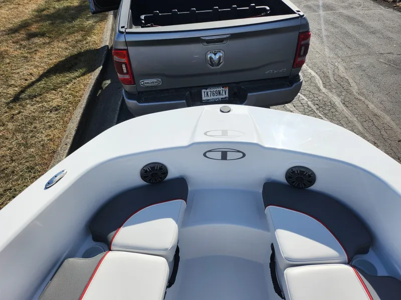 Slide: The Image of 2023 Tahoe T18 boat interior near a parked gray truck. - 16