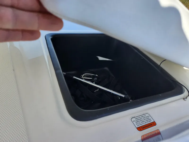 Slide: The Image of Open storage compartment in 2023 Tahoe T18 boat, showing interior contents. - 22