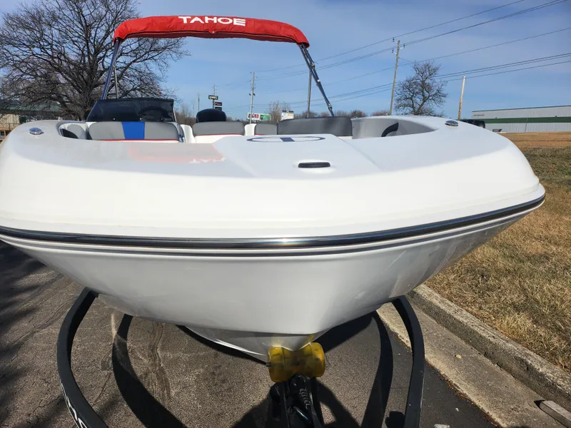 Slide: The Image of 2023 Tahoe T18 boat with red canopy on trailer, parked outdoors. - 6