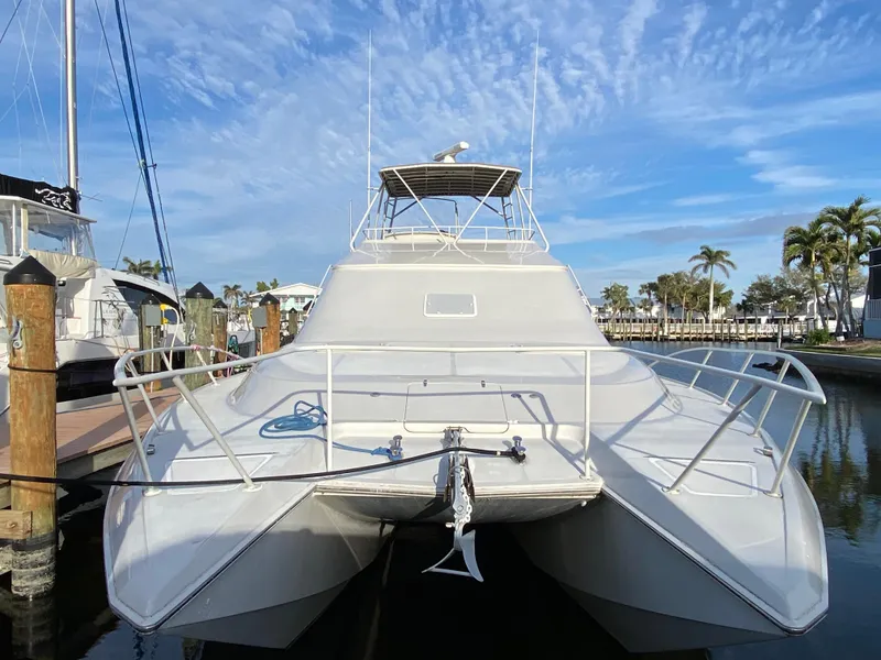 Slide: The Image of 1995 Mares 58 Power Catamaran docked, showcasing sleek design and spacious deck. - 2