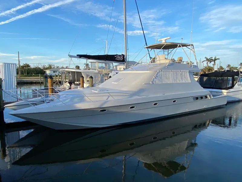 Slide: The Image of 1995 Mares 58 Power Cat yacht docked in a marina under a clear blue sky. - 28