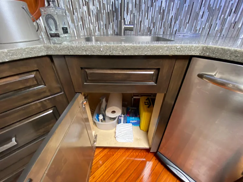 Slide: The Image of Kitchen cabinet on Mares 58 Power Cat 1995, open to reveal cleaning supplies and paper towels. - 43