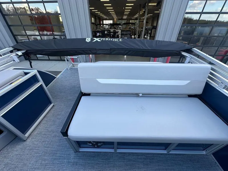 Slide: The Image of 2025 Godfrey Xperience 2286 SFLX boat interior with white seating and covered deck. - 6