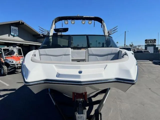 Slide: The Image of 2022 MasterCraft NXT20 boat, white exterior, parked outdoors on a sunny day. - 3