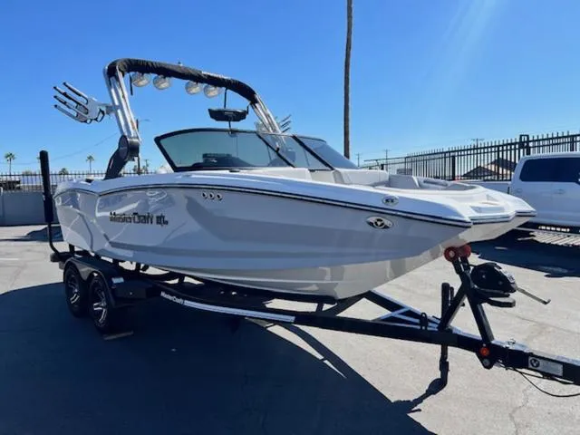 Slide: The Image of 2022 MasterCraft NXT20 boat on trailer, sleek design, parked outdoors under clear sky. - 4