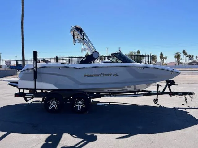Slide: The Image of 2022 MasterCraft NXT20 boat on trailer, side view, outdoors, clear sky. - 5