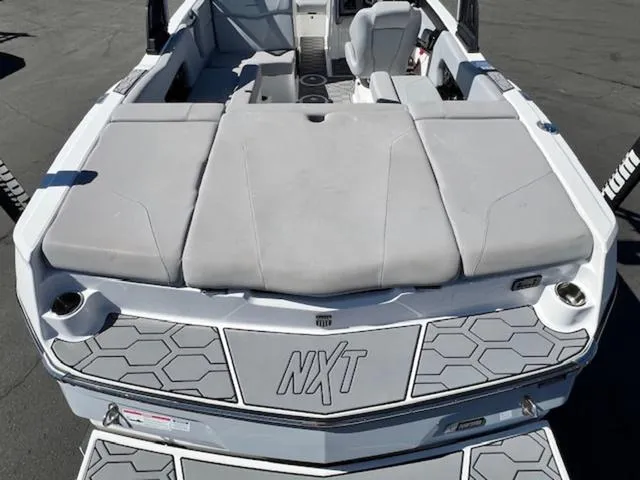 Slide: The Image of 2022 MasterCraft NXT20 boat, rear view with cushioned seating and hexagonal design. - 9