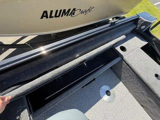 Slide: The Image of 2024 Alumacraft Classic 165 Side Console boat interior with open storage compartment. - 10