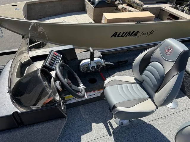 Slide: The Image of 2024 Alumacraft Classic 165 Side Console boat interior with steering wheel and seat. - 12