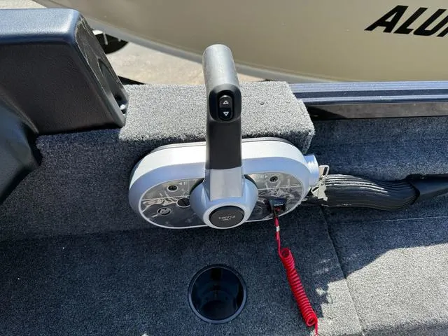 Slide: The Image of 2024 Alumacraft Classic 165 Side Console throttle control with safety lanyard on carpeted surface. - 13