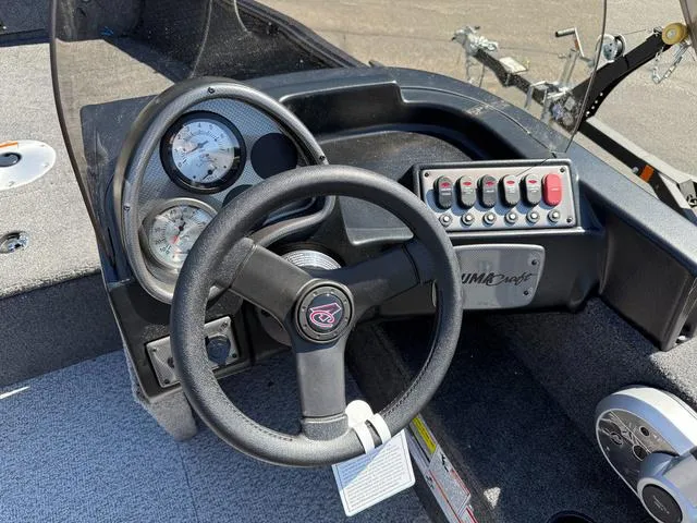 Slide: The Image of 2024 Alumacraft Classic 165 Side Console dashboard with steering wheel and control panel. - 14