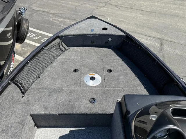 Slide: The Image of 2024 Alumacraft Classic 165 Side Console boat interior with carpeted deck and storage netting. - 15