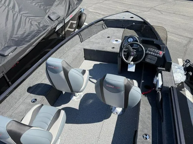 Slide: The Image of 2024 Alumacraft Classic 165 Side Console boat interior with two seats and steering console. - 4