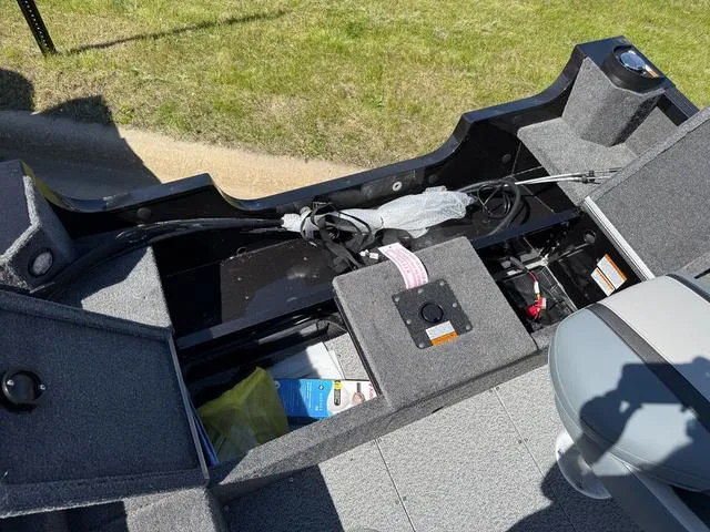 Slide: The Image of 2024 Alumacraft Classic 165 Side Console boat interior with storage compartments open. - 6