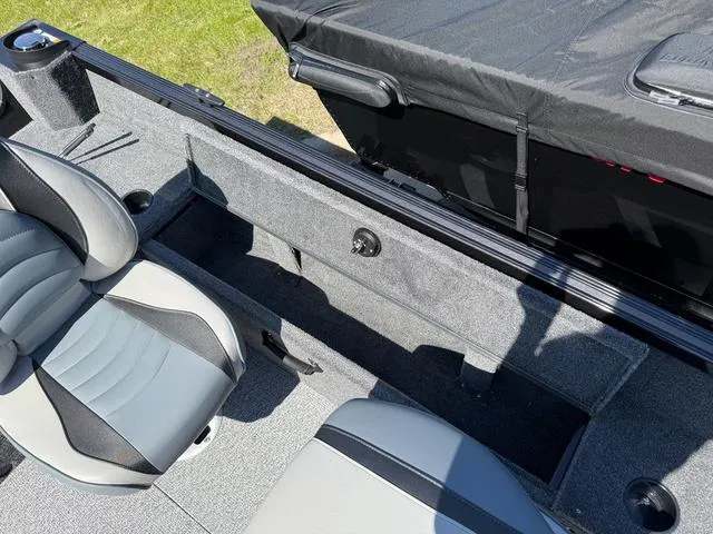 Slide: The Image of 2024 Alumacraft Classic 165 Side Console interior with gray seating and storage compartments. - 8
