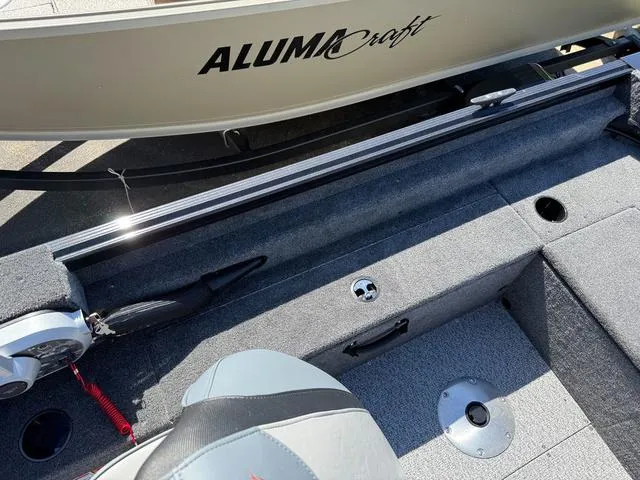 Slide: The Image of 2024 Alumacraft Classic 165 Side Console boat interior with seating and storage compartments. - 9