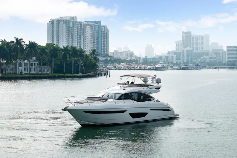Slide: The Image of 2017 Princess S65 yacht cruising in a city harbor with skyscrapers in the background. - 5