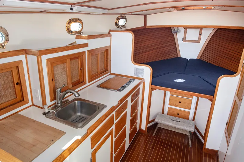 Slide: The Image of 1985 Wilbur 34 yacht interior with wooden cabinetry and cozy sleeping area. - 11