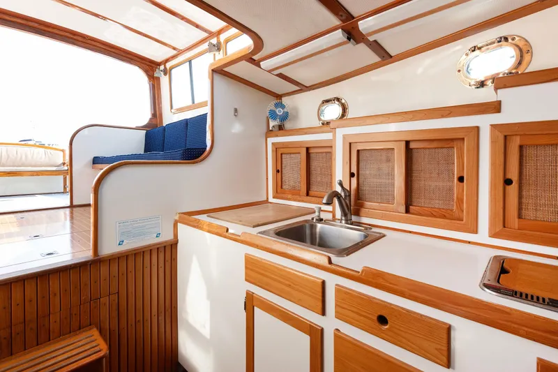 Slide: The Image of 1985 Wilbur 34 boat interior with wooden cabinetry and sink in galley area. - 12